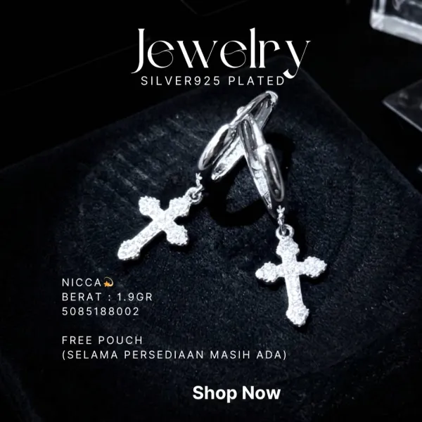 Anting perak 925 model Nicca huggie dengan liontin salib zirkonia di atas kain hitam